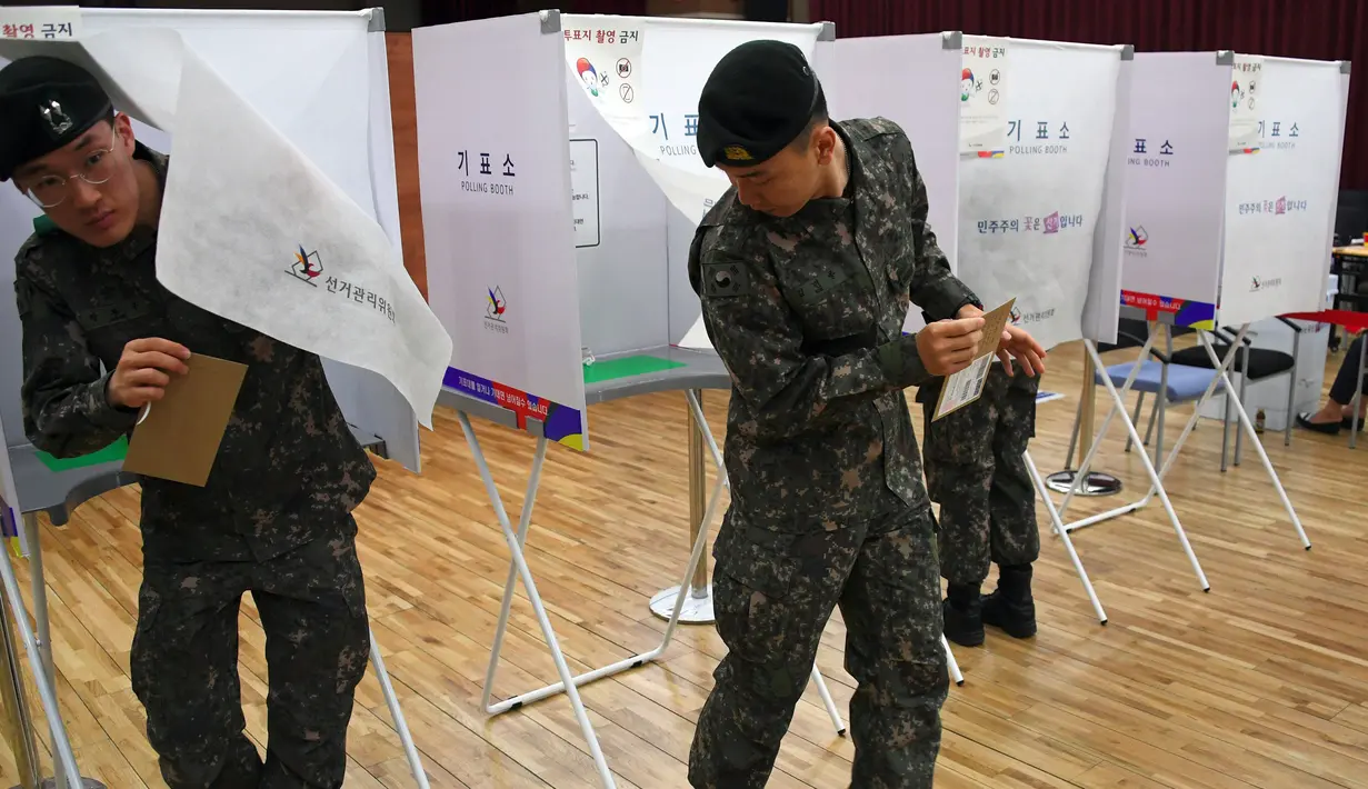 Tentara Korea Selatan (Korsel)  keluar dari bilik suara di sebuah TPS di Seoul, Kamis (4/5). Selama 2 hari, masyarakat yang terdaftar sebagai pemilih dapat memberikan suara sebelum pemilihan presiden (Pilpres) pada 9 Mei mendatang. (JUNG Yeon-Je/AFP)