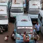 Pedagang menungu calon pembeli diantara deretan angkot di Terminal Kampung Melayu, Jakarta, Rabu (12/7). Angkot ber-AC ini merupakan bagian dari upaya untuk meningkatkan pelayanan angkutan umum kepada masyarakat. (Liputan6.com/Immanuel Antonius)