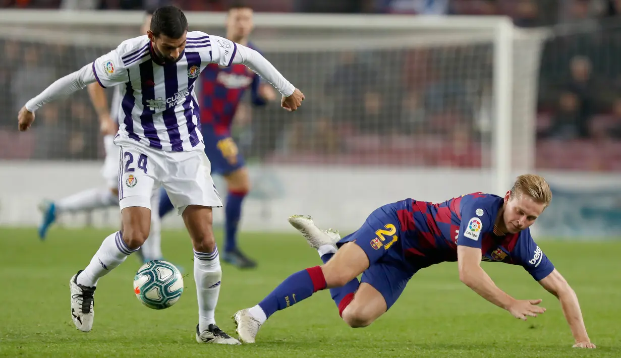 Pemain Real Valladolid Joaquin Fernandez berebut bola dengan  gelandang Barcelona, Frenkie de Jong  pada pertandingan pekan ke-11 La Liga  di Camp Nou, Selasa (29/10/2019). Barcelona sukses merebut puncak klasemen La Liga pekan ini setelah menang telak 5-1 atas Valladolid. (AP/Joan Monfort)
