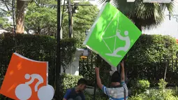 Pekerja memasang neon box Asian Games di depan Balai Kota DKI Jakarta, Jumat (6/7).Lampu neon box berwarna warni yang dipasang menggambarkan berbagai cabang olahraga yang akan dipertandingkan dalam Asian Games 2018. (Liputan6.com/Arya Manggala)