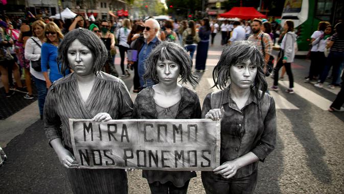 Tiga wanita membawa pesan bertuliskan 'Lihat bagaimana kita berakhir' saat menggelar demonstrasi memperingati Hari Perempuan Internasional di Buenos Aires, Argentina, Jumat (8/3). (AP Photo/Natacha Pisarenko)