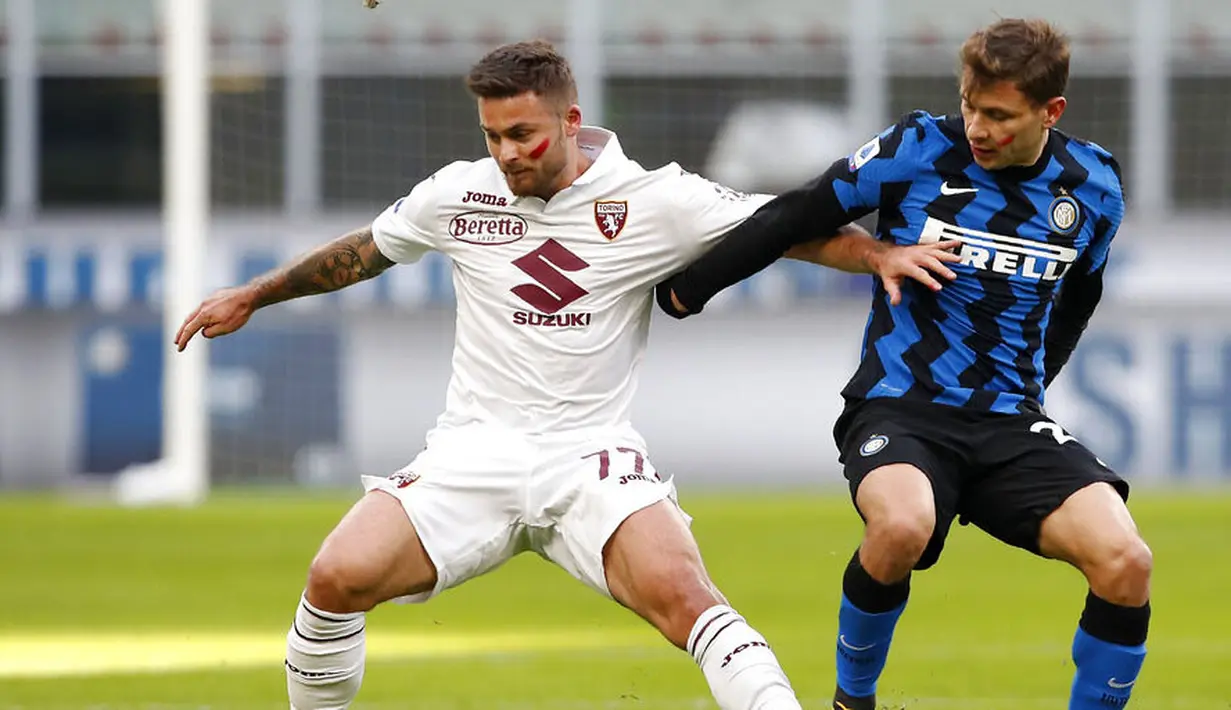 Pemain Inter Milan, Nicolo Barella, berebut bola dengan pemain Torino, Karol Linetty, pada laga Liga Italia di Stadion Giuseppe Meazza, Minggu (22/11/2020). Inter Milan menang dengan skor 4-2. (AP/Antonio Calanni)