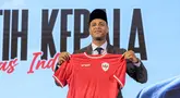 Pelatih kepala baru Timnas Indonesia, Patrick Kluivert berpose dengan memegang jersey dan memakai peci setelah sesi konferensi pers yang berlangsung di Hotel Mulia, Senayan, Jakarta, Minggu (12/01/2025). (Bola.com/Bagaskara Lazuardi)