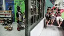 Anak-anak membaca buku (kiri) sementara yang lainnya makan (kanan) di Pojok Baca Kampung Literasi RW 09, Kampung Pondok Jati, Palmeriam, Jakarta Timur, Senin (10/10/2022). Pemerintah Provinsi DKI Jakarta berkolaborasi dengan Kelurahan Palmeriam dan Komunitas Bale Buku Jakarta membangun Pojok Baca Palmeriam. (merdeka.com/Iqbal S. Nugroho)