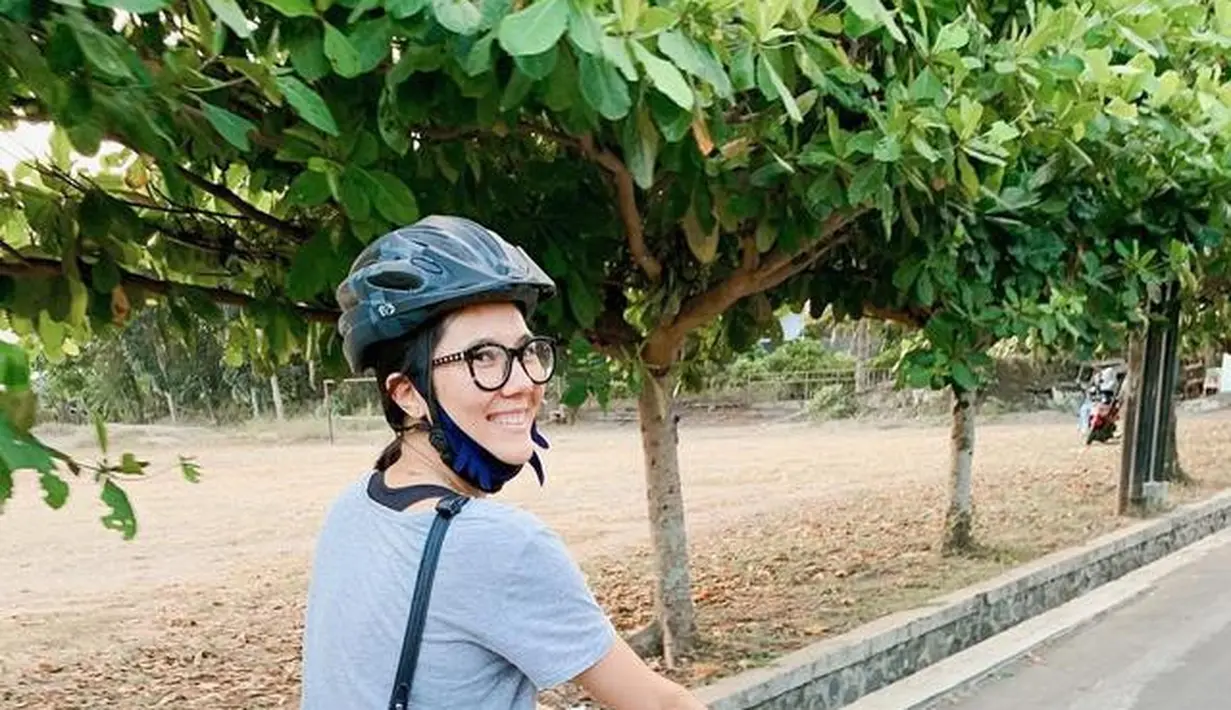 Begitu juga ketika mengendarai sepeda. Ia memilih mengenakan sneakers, legging, dan t-shirt favorit. [Foto: Instagram/ Sarah Candra]