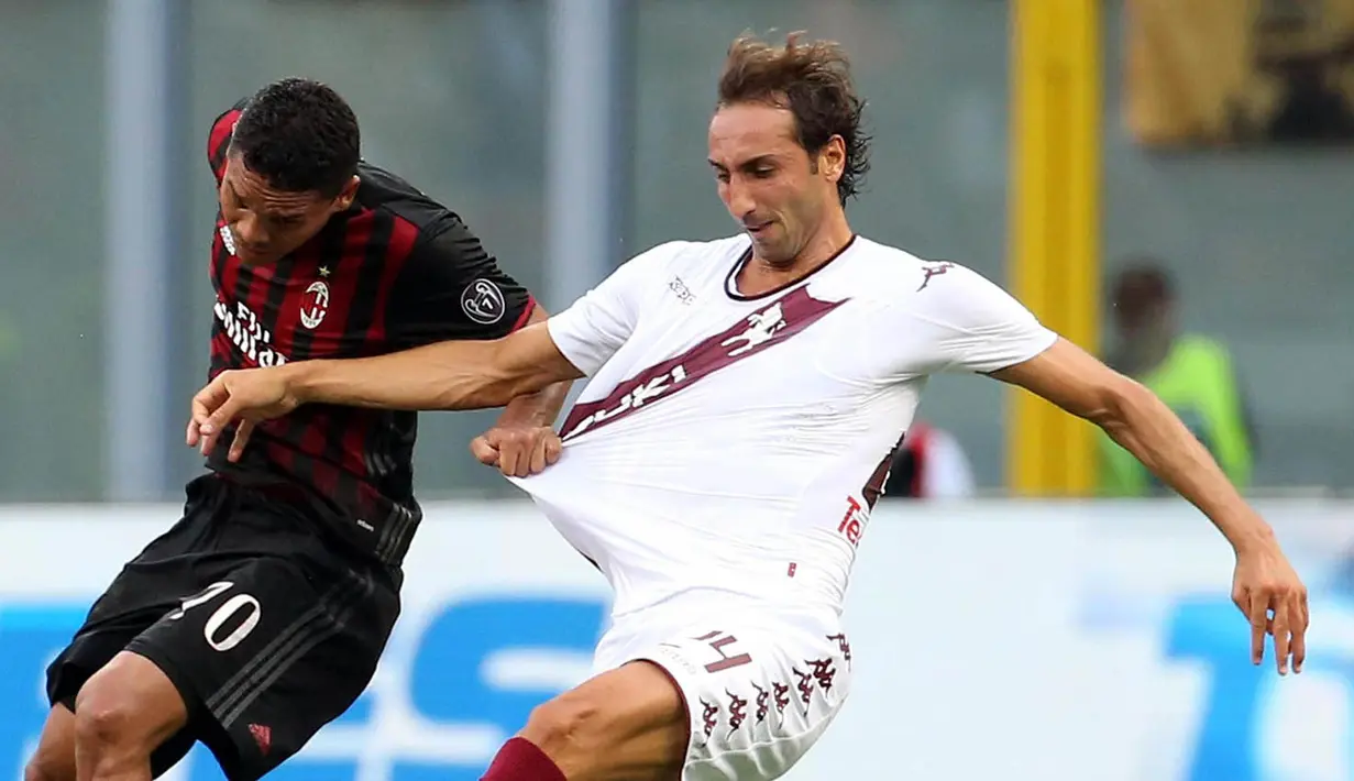 Striker AC Milan, Carlos Bacca, menarik baju pemain Torino, Emiliano Moretti. Wasit mengeluarkan satu kartu merah serta satu kartu kuning kepada pemain Milan dan juga tiga kartu kuning untuk Torino. (EPA/Matteo Bazzi)