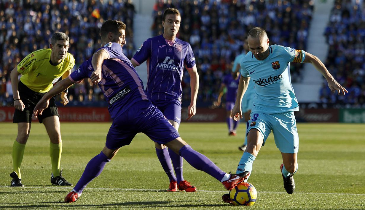 Gelandang Barcelona, Andres Iniesta, berusaha melewati gelandang Leganes, Ruben Perez, pada laga La Liga Spanyol di Stadion Butarque, Leganes, Sabtu (18/11/2017). Leganes kalah 0-3 dari Barcelona. (AFP/Oscar Del Pozo)