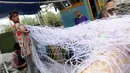 Nelayan merapihkan jaring di Karangsong, Indramayu, Jawa Barat, Jumat (15/1). Untuk mengisi waktu luang saat tidak melaut karena cuaca buruk, nelayan di kawasan tersebut menggunakan waktu mereka untuk memperbaiki jaring. (Liputan6.com/Helmi Afandi)