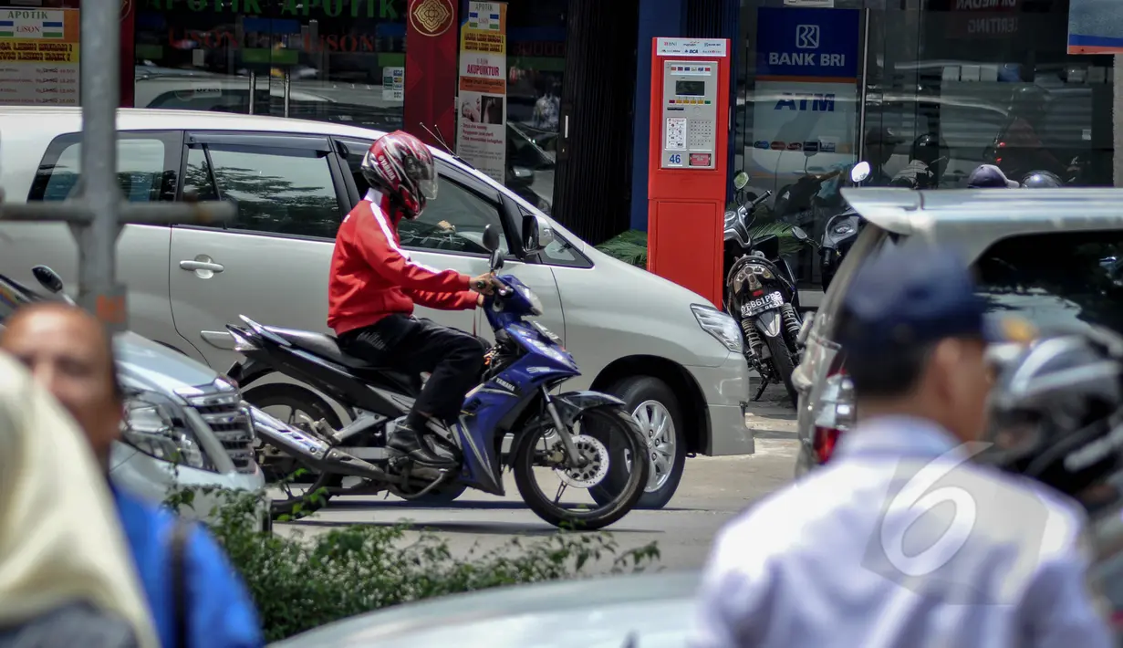 Sejumlah kendaraan melintas di depan mesin parkir meter di Jalan Boulevard Raya, Kelapa Gading, Jakarta, Rabu (25/3/2015). Pembayaran parkir elektronik tersebut bertujuan untuk mempermudah masyarakat dalam melakukan transaksi. (Liputan6.com/Faizal Fanani)