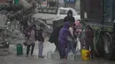 Situasi ini disebabkan kerusakan infrastruktur air dan sanitasi yang meluas, blokade bantuan kemanusiaan, dan minimnya pasokan air yang layak minum. Tampak dalam foto, anak-anak Palestina mengumpulkan air dari sebuah truk di tengah hujan deras di kawasan Sheikh Radwan, Kota Gaza, Jumat 14 November 2025. (AP Photo/Jehad Alshrafi)