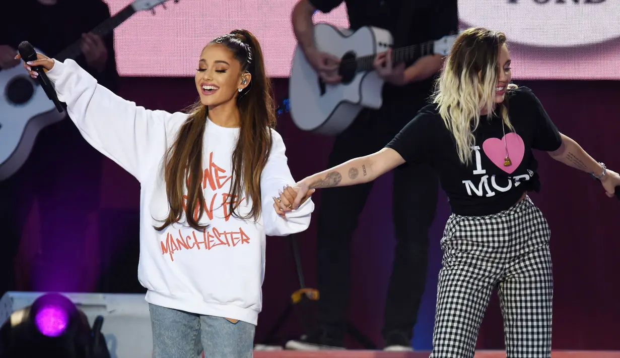 Ariana Grande bersama Miley Cyrus membawakan lagu dalam konser amal bertajuk "One Love Manchester" di Manchester, Minggu (4/6). Konser itu untuk mengenang dan menggalang dana bagi para korban bom di konser Ariana Grande 22 Mei silam. (Dave Hogan via AP)