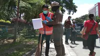 Personel Pol PP Palu saat memberian sanksi membersihkan jalan kepada pelanggar protokol kesehatan di Kota Palu yang terjaring saat operasi yustisi di jalan Mohamad Hatta, Kamis (1/10/2020). (Foto: Liputan6.com/ Heri Susanto).