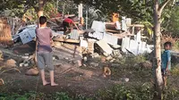 Warga memeriksa reruntuhan rumah yang rusak akibat gempa di Lombok, NTB, Minggu (29/7). Data sementara mencatat, gempa bumi tektonik 6.4 SR itu mengakibatkan 10 orang meninggal dunia dan puluhan rumah rusak. (HO/NTB DISASTER MITIGATION AGENCY/AFP)