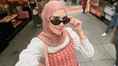 <p>Syahnaz Sadiqah tampaknya konsisten berhijab. Gayanya saat ini dipuji makin cantik dan adem saat dilihat, termasuk potret yang satu ini. Ia tampil mengenakan set atasan tanpa lengan dan celana knitted bernuansa merah-oranye, dipadukan dengan oversized atasan putih sebagai inner, dan hijab cokelat yang serasi. [Foto: Instagram/syahnazs]</p>