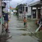 Sejumlah warga terpaksa menyewa sampan untuk bisa melintasi Jalan Cigebar yang terendam banjir, Kecamatan Bojongsoang, Bandung, Selasa, 19 April 2022. (Liputan6.com/Dikdik Ripaldi)