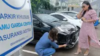 Teknisi mengecek kendaraan pelanggan perempuan di Grha Asuransi Astra, Jakarta. (Liputan6.com)