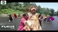 Alih-alih melintasi jalan provinsi yang memutar sejauh belasan kilometer, rombongan pasangan pengantin memilih menyeberangi sungai karena lebih dekat.