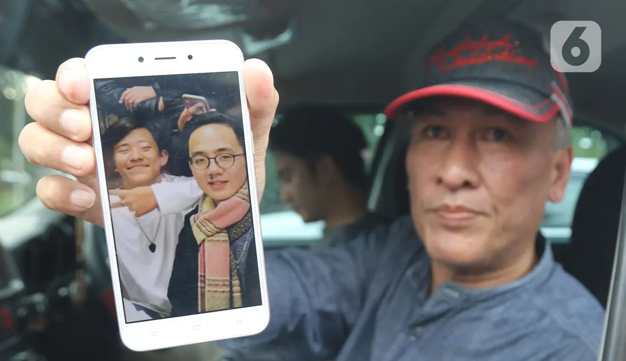 Pihak keluarga menunjukan foto anggota saat menunggu kepulangan WNI yang sudah selesai menjalani observasi di Natuna, di Bandara Halim Perdana Kusuma, Jakarta, Sabtu (15/2/2020). Pemerintah resmi memulangkan 238 WNI ke daerah masing-masing karena telah dinyatakan sehat (Liputan6.com/Herman Zakharia)