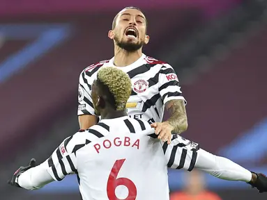 Pemain Manchester United, Paul Pogba, melakukan selebrasi bersama Alex Telles usai mencetak gol ke gawang West Ham United pada laga Liga Inggris di Stadion London, Minggu (6/12/2020). Setan Merah menang dengan skor 1-3. (Justin Setterfield/Pool Via AP)