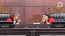 Ketua Mahkamah Konstitusi (MK) Suhartoyo (kanan) berbicara dengan Hakim Konstitusi Saldi Isra (kiri) di sela sidang perkara Nomor 145/PUU-XXI/2023 di Gedung MK, Jakarta, Selasa (16/1/2024). (Liputan6.com/Angga Yuniar)