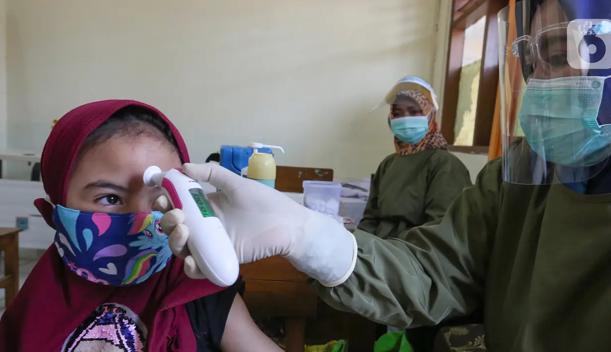 Siswa sedang diukur suhu tubuh sebelum imunisasi campak pada Bulan Imunisasi Anak Sekolah (BIAS) di SDN Serua 3, Ciputat, Tangerang Selatan, Rabu (2/9/2020). Pemberian vaksin tersebut untuk sistem kekebalan tubuh dan mengurangi risiko anak terkena penyakit. (Liputan6.com/Fery Pradolo)