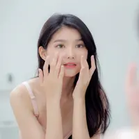 Seorang wanita muda cantik sedang mengoleskan krim untuk merawat kulit wajahnya. (depositphotos.com/nnudoo)