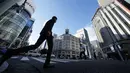 Warga yang mengenakan masker untuk membantu mengekang penyebaran COVID-19 berjalan di sepanjang penyeberangan pejalan kaki di Tokyo, Jepang, Selasa (27/7/2021). Tokyo melaporkan jumlah kasus harian COVID-19 tertinggi beberapa hari setelah Olimpiade dimulai. (AP Photo/Eugene Hoshiko)