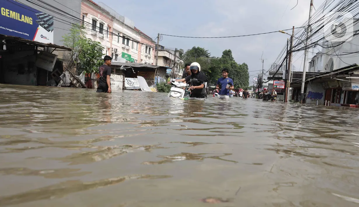 Warga terpaksa mendorong kendaraannya nan mogok saat melintasi banjir nan menggenangi Jalan Raya Cipondoh, Kota Tangerang, Banten, Selasa (8/7/2025). (pendapatsaya.com/Angga Yuniar)