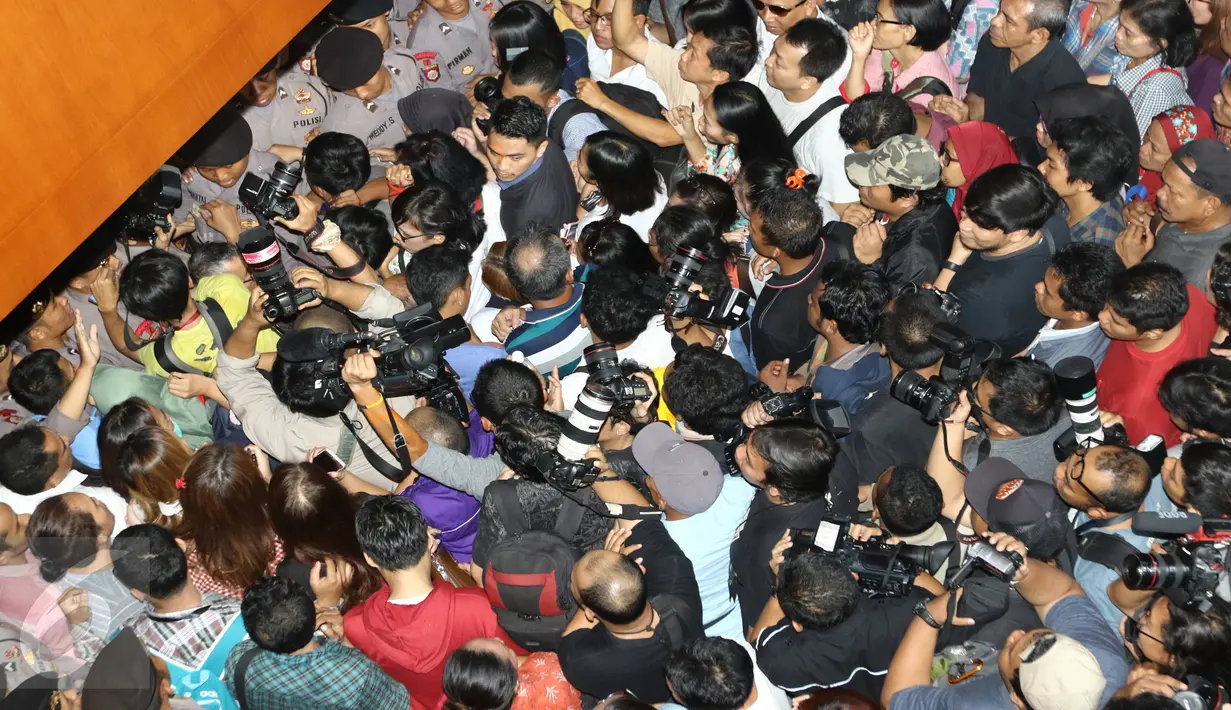 Pengunjung dan awak media berdesakan di depan pintu masuk ruang Sidang Vonis Jesicca, di PN Jakarta Pusat,Kamis (27/10). Jelang vonis Jessica,  kepolisian dan petugas PN memperketat penjagaan pintu masuk. (Liputan6.com/Helmi Affandi)