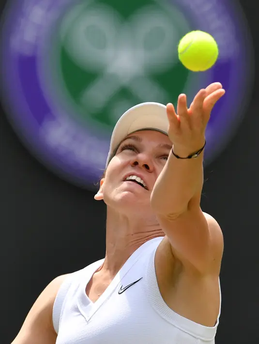 Petenis Rumania, Simona Halep bersiap mengembalikan bola ke arah lawannya petenis China, Shuai Zhang pada perempat final Grand Slam Wimbledon di London, Selasa (9/7/2019). Halep mengalahkan petenis non-unggulan asal China dengan memetik kemenangan 7-6, 6-1. (GLYN KIRK / AFP)