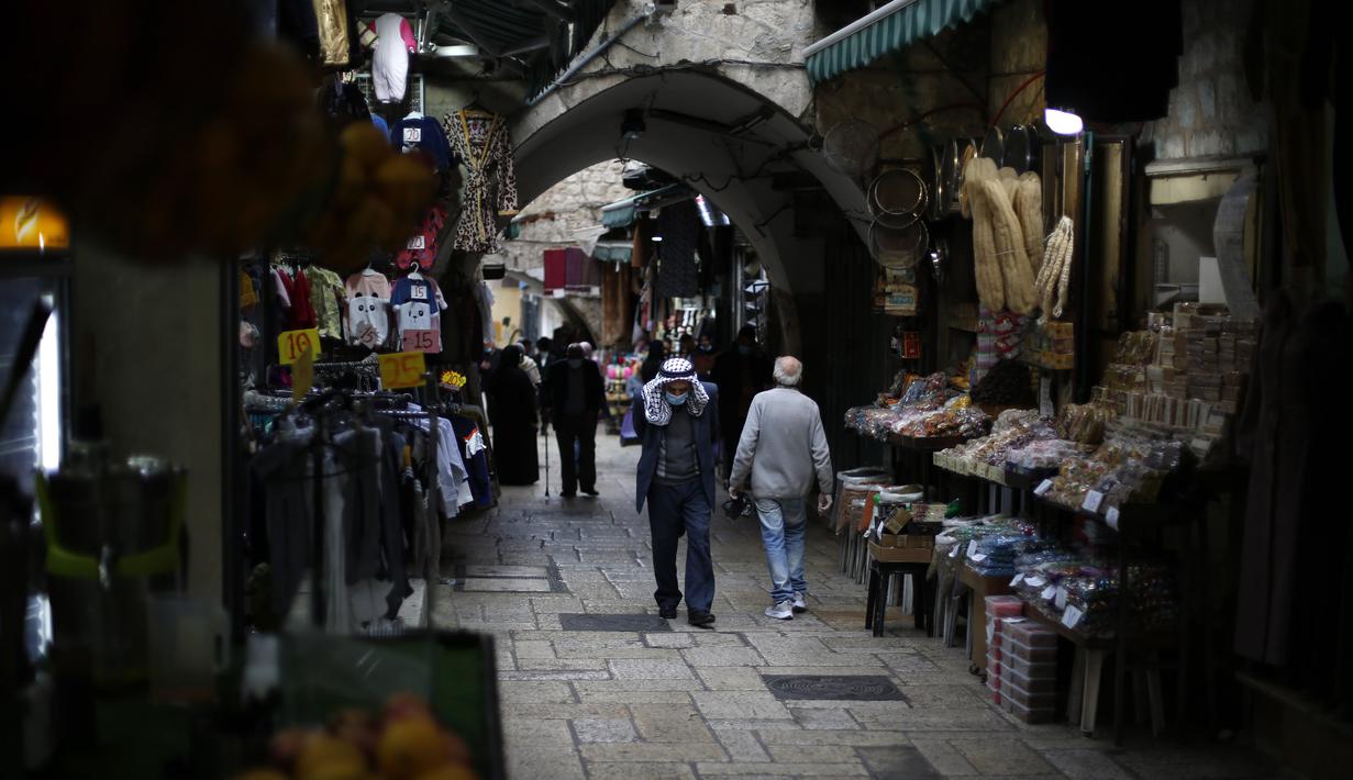 Orang-orang yang mengenakan masker terlihat di luar Kota Tua Yerusalem di tengah pandemi COVID-19 (25/11/2020). (Xinhua/Muammar Awad)