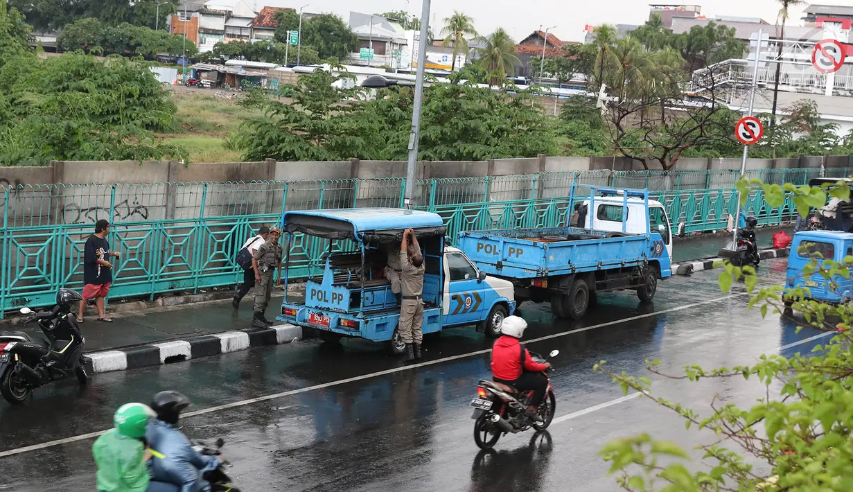 Personel Satpol PP berjaga di sekitar trotoar kawasan Senen, Jakarta, Kamis (22/11). Penjagaan itu menyebabkan trotoar di kawasan Senen bebas dari PKL yang biasa berjualan pakaian bekas. (Liputan6.com/Immanuel Antonius)