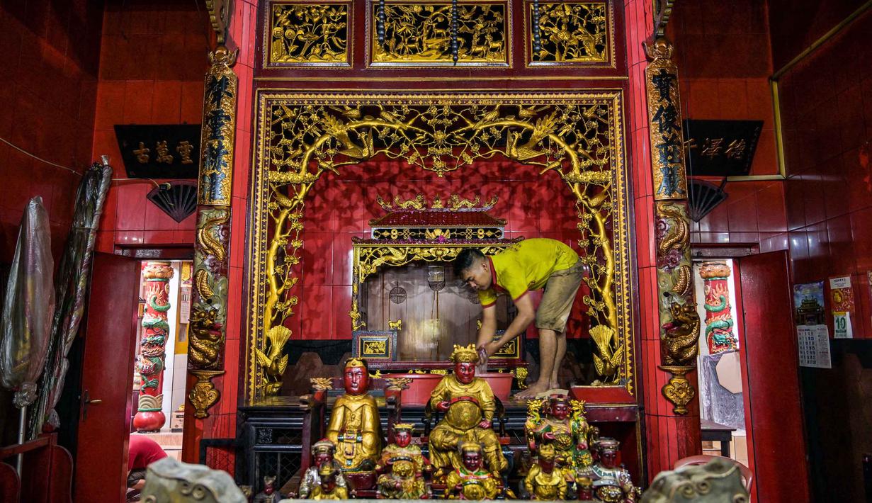 Selain cuci Rupang, persiapan Imlek juga meliputi pergantian lampion, lilin, serta sembahyang kepada leluhur. Tampak dalam foto, para sukarelawan membersihkan patung-patung dewa di Kuil Hong San Ko Tee, Surabaya, Jawa Timur, pada Rabu 11 Februari 2026. (JUNI KRISWANTO/AFP)