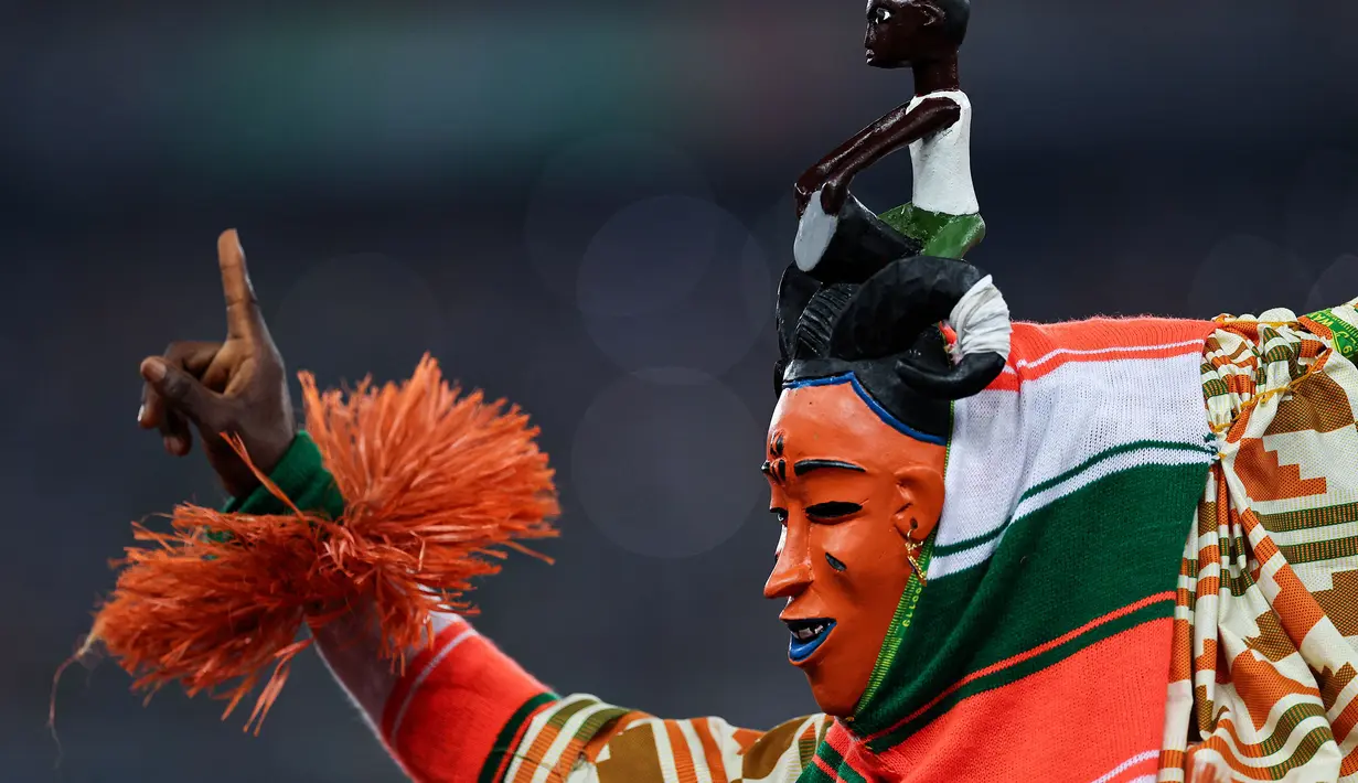 Seorang penampil saat pesta pembukaan Piala Afrika 2023 yang berlangsung di Stadion Alassane Ouattara Olympic, Abidjan, Pantai Gading, Minggu (14/01/2024) dini hari WIB. (AFP/Franck Fife)