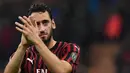 Gelandang AC Milan, Hakan Calhanoglu, menyapa suporter usai melawan Lecce pada laga Serie A Italia di Stadion San Siro, Milan, Minggu (20/10). Kedua klub bermain imbang 2-2. (AFP/Miguel Medina)