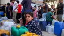 Orang-orang yang terlantar akibat perang menunggu dengan wadah air untuk mengisi persediaan mereka dari tangki air di kamp penampungan, Khan Yunis, Jalur Gaza Selatan pada 6 Juni 2026. (Bashar Taleb/AFP)
