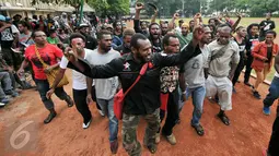 Ratusan mahasiswa Aliansi Mahasiswa Papua (AMP) menari sambil berteriak di lapangan Sahabara Polda Metro, Jakarta, Selasa (1/12/2015). Mereka menunggu ratusan kawan mereka yang diamankan Polisi. (Liputan6.com/Yoppy Renato)