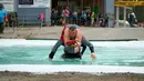 Kontestan pria menggendong pasangannya melewati air saat mengikuti kejuaraan dunia ke-24 lomba lari gendong istri di Sonkajarvi, Finlandia, Sabtu (6/7/2019). Pasangan yang mengikuti lomba ini tidaklah harus benar-benar sudah menikah. (AP Photo/David Keyton)