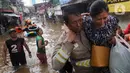 Petugas mengevakuasi warga korban banjir di kawasan Karet Pasar Baru Barat, Jakarta, Selasa (25/2/2020). Banjir yang terjadi sejak subuh akibat luapan Kanal Banjir Barat tersebut merendam ratusan rumah hingga setinggi dua meter. (merdeka.com/Arie Basuki)