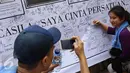 Warga berfoto dengan latar belakang spanduk bergambar tokoh nasional yang penuh tanda tangan di area car free day, Jakarta, Minggu (14/5). (Liputan6.com/Immanuel Antonius)