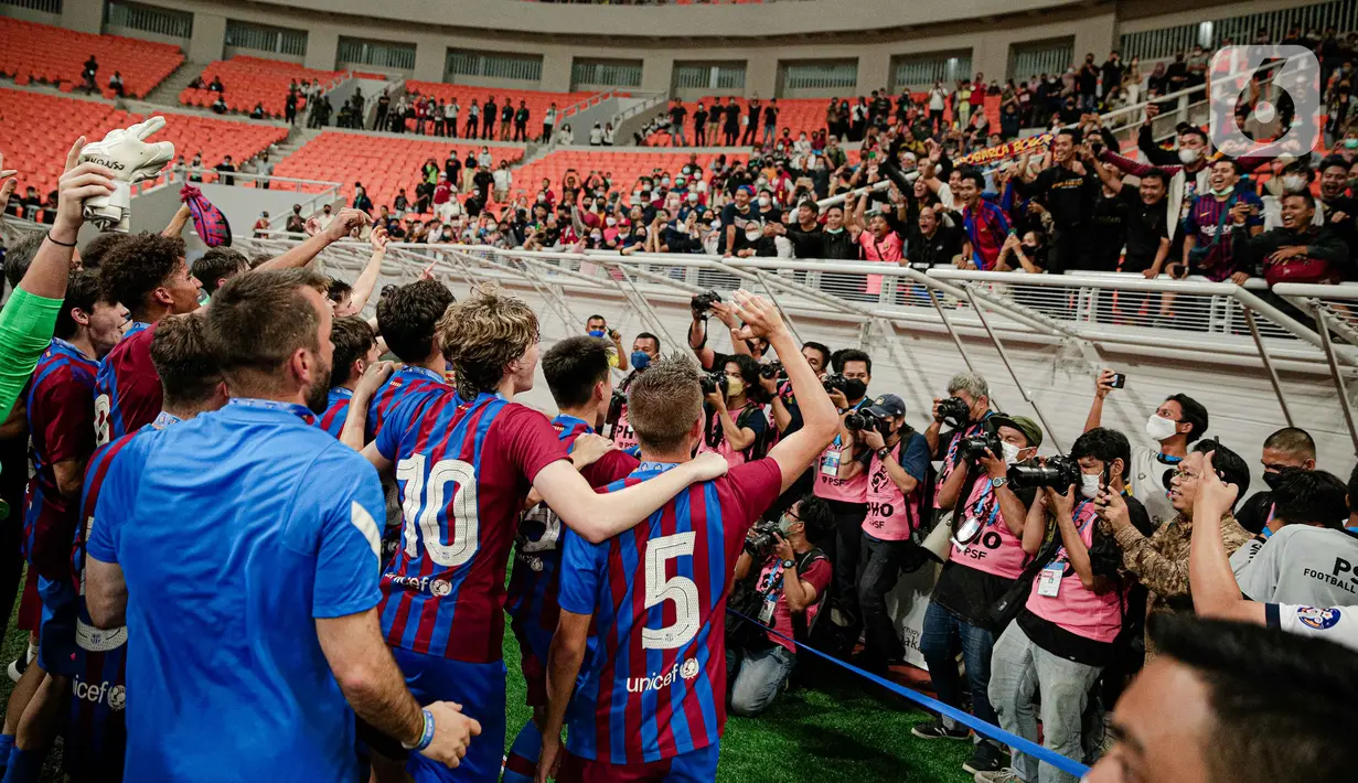 Para pemain Barcelona U-18 menyapa fans usai menjadi juara International Youth Championship (IYC) 2021 di Jakarta International Stadium (JIS), Jakarta, Selasa (19/4/2022). Barcelona U-18 juara IYC 2021 usai menang atas Altetico Madrid U-18. (Liputan6.com/Faizal Fanani)