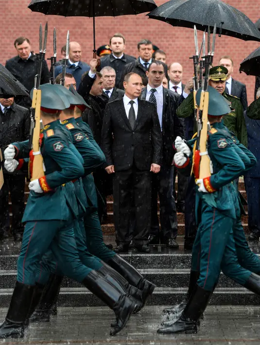Presiden Rusia, Vladimir Putin memeriksa pasukan kehormatan sebelum meletakkan karangan bunga ke makam prajurit tak dikenal pada peringatan invasi Nazi Jerman ke 76 tahun di Moskow, Kamis (22/6). (Alexei Druzhinin/Sputnik, Kremlin Pool Photo via AP)