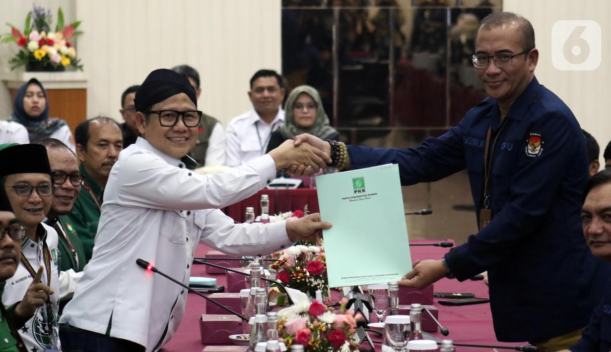 Ketua Umum Partai Kebangkitan Bangsa (PKB), Muhaimin Iskandar (kiri berdiri) menyerahkan berkas Bakal Calon Legislatif (Bacaleg) kepada Ketua Komisi Pemilihan Umum (KPU) Republik Indonesia, Hasyim Asy'ari di Gedung KPU RI, Jakarta, Sabtu (13/5/2023). (Liputan6.com/Helmi Fithriansyah)