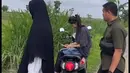 Saat sang suami turun dari motor dan melihat-lihat sawah, Azizah Salsha tampak duduk di motor. 
 [Youtube/momenbucin]
