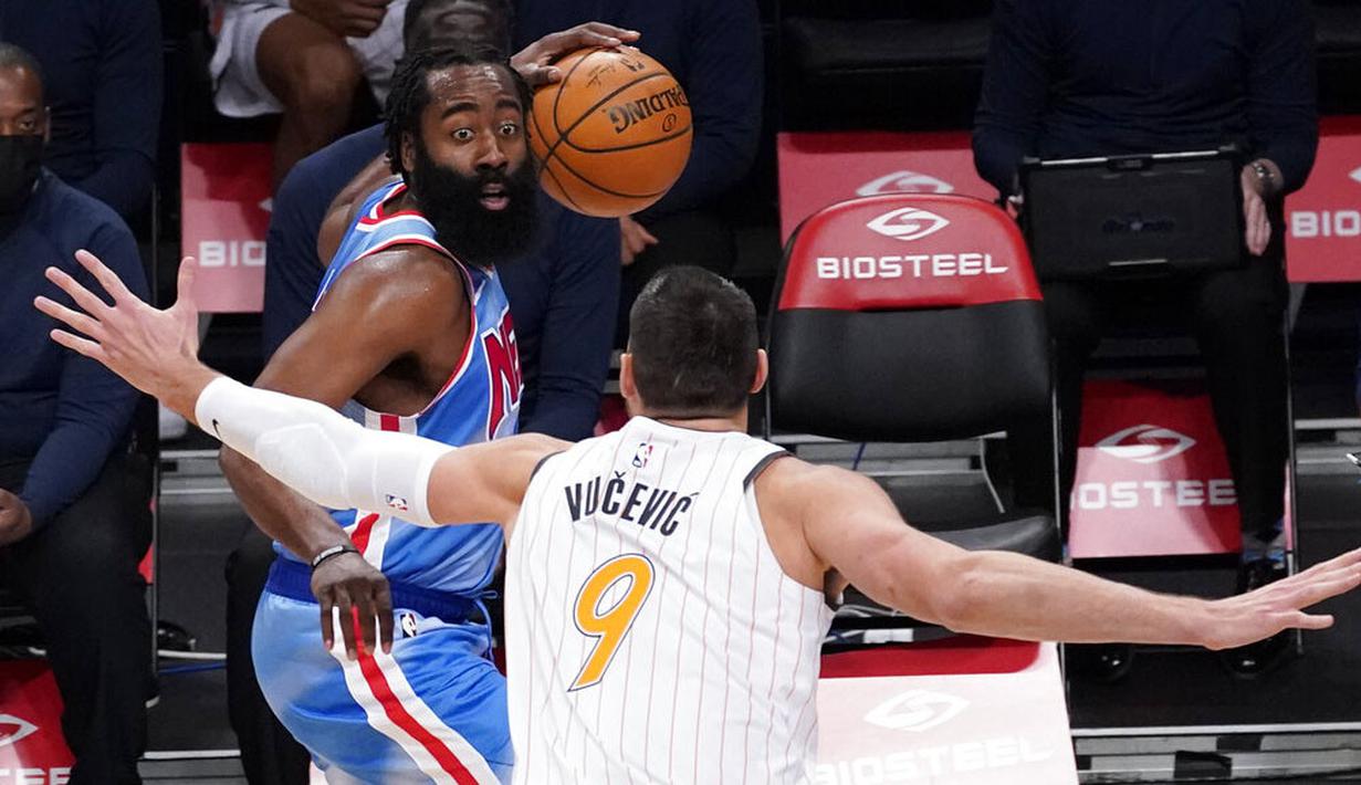 Pebasket Brooklyn Nets, James Harden, berusaha melewati pebasket Orlando Magic, Nikola Vucevic, pada laga NBA, Sabtu (16/1/2021). Nets menang dengan skor 122-115. (AP Photo/Mary Altaffer)