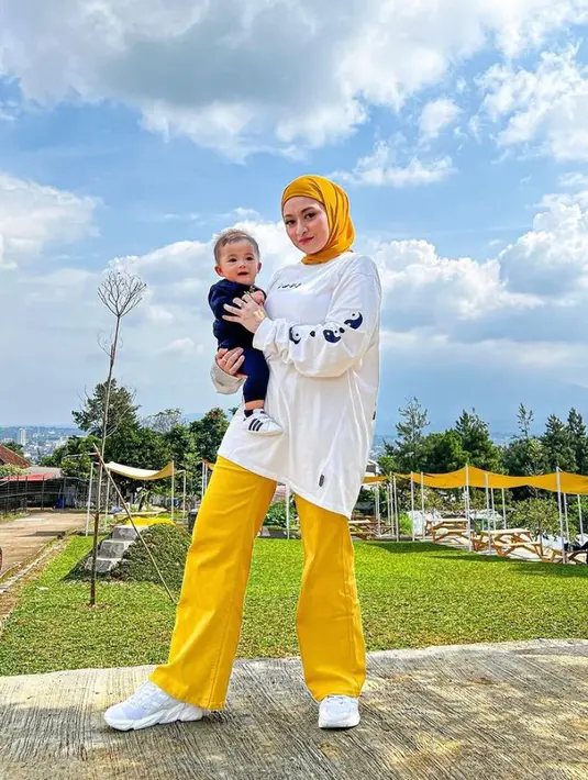 1. Tampil ala cewek kue, Nathalie memadukan oversized sweater warna putih dengan celana kulot berwarna kuning, serta hijab berwarna senada. (Instagram/nathalieholscher).