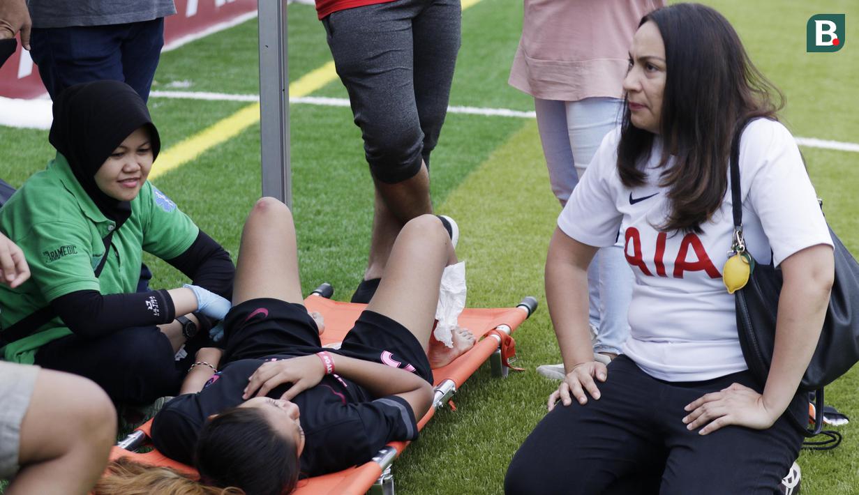 Head of Brand Communication, PT AIA FINANCIAL, Kathryn Monika Parapak, melihat pemain yang cedera saat Kompetisi Nasional AIA di Lapangan TNI AU, Jakarta, Sabtu (01/12). 16 orang terpilih akan bertanding di Bangkok. (Bola.com/M Iqbal Ichsan)