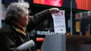 Seorang perempuan menghancurkan kertas berisi kenangan menyulitkan selama kegiatan Good Riddance Day ke-13 tahunan di Times Square, New York, 28 Desember 2019. Kegiatan menjelang tahun baru tersebut menjadi tradisi untuk menghapus kenangan buruk selama satu tahun. (Kena Betancur / AFP)