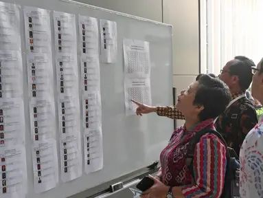 Sejumlah Capim KPK melihat daftar nama di Pusdiklat Kemensetneg, Jakarta, Minggu (28/7/2019). Tes psikologi ini diikuti oleh 104 peserta setelah melalui proses seleksi pada tes administrasi. (Liputan6.com/Herman Zakharia)