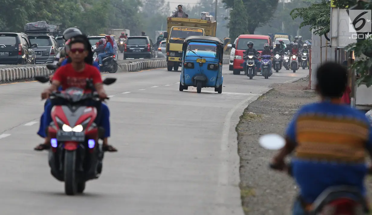 Pemudik bersama keluarganya menggunakan bajaj saat perjalanan mudik melintasi Jalur Pantura kawasan Patrol, Jawa Barat, Senin (3/6/2019). Keluarga ini memanfaatkan bajajnya sebagai angkutan mudik dari Jakarta menuju kampung halamannya di Cirebon, Jawa Tengah. (Liputan6.com/Herman Zakharia)